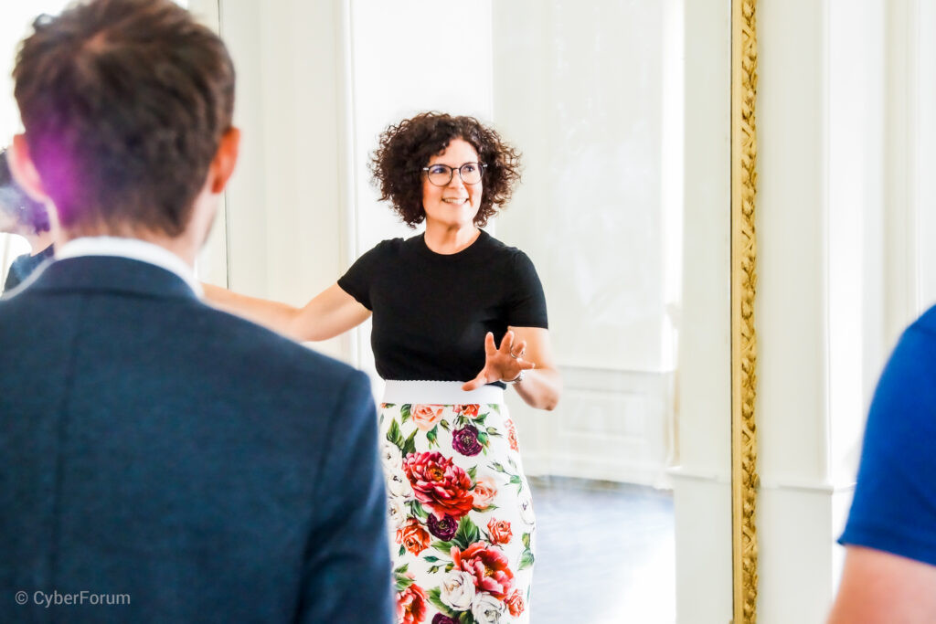 Das Bild zeigt eine Frau, die eine Präsentation hält.