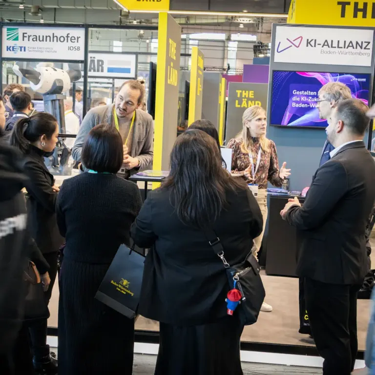 Jan Zipp und Sandra Schorrer am Stand der KI-Allianz bei der Hannover Messe 2026.